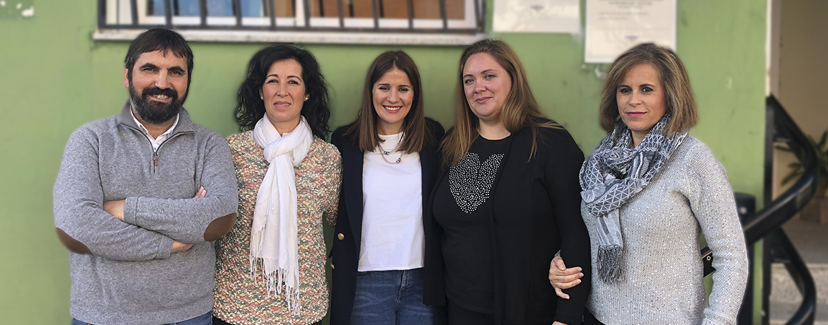 De derecha a izquierda, Paula persona sorda y de la junta directiva de ADABA, madre de niña sorda, Isabel Gil Rosiña Portavoz de la Junta de Extremadura, madre de niño sordo, y Severiano Sevilla Gerente de FEDAPAS Cinco personas juntas soriendo mirando a la cámara en la fachada de FEDAPAS